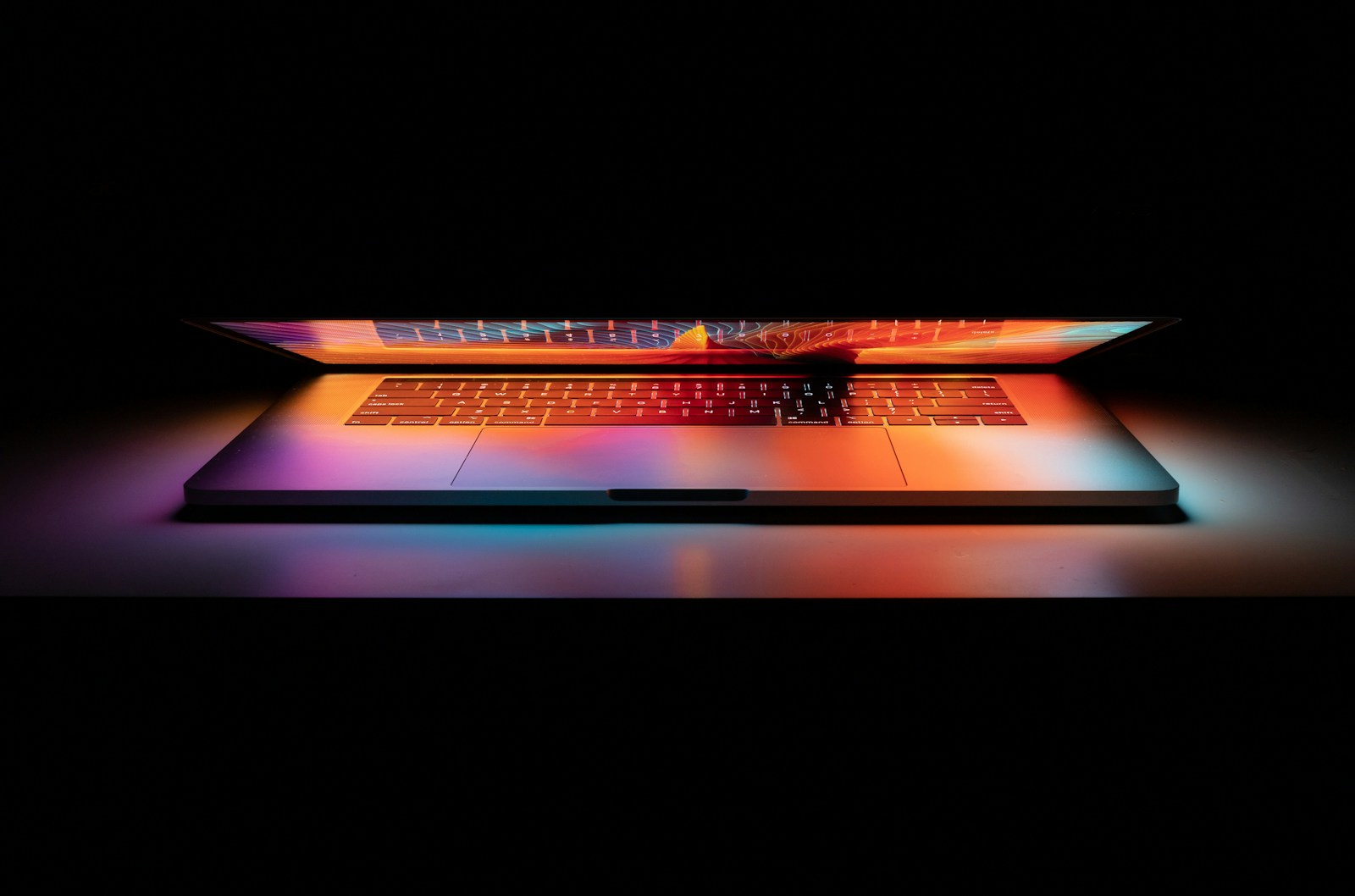 MacBook Pro on white surface symbolizing cyber risks for business